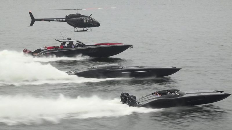 Three offshore powerboats running in formation under a helicopter